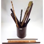 A collection of various swagger sticks, circular rulers and measuring sticks etc. in leather bin (