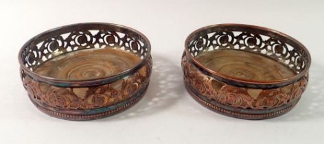 A pair of Georgian silver plate on copper bottle coasters on turned wood bases