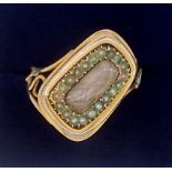 A Victorian gold mourning ring with diagonally set hair locket within seed pearl surround, unmarked,