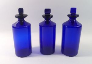 Three Bristol blue pharmacy jars and covers, 23cm tall