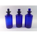 Three Bristol blue pharmacy jars and covers, 23cm tall