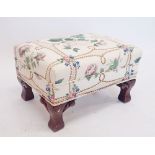 A Victorian floral upholstered footstool on carved scroll feet