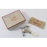 A silver hallmarked rattle with mother of pearl handle, boxed