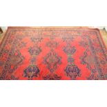 A large Turkish carpet with blue and green motifs on a red ground, 340 x 368cm