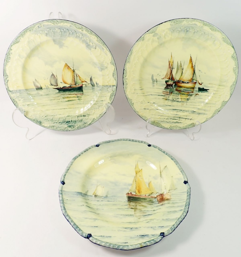 A set of three Royal Crown Derby plates painted yachts and sailing boats, 25.5cm diameter
