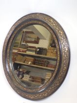 An oval ebonised and gilt framed mirror, 42 x 38cm