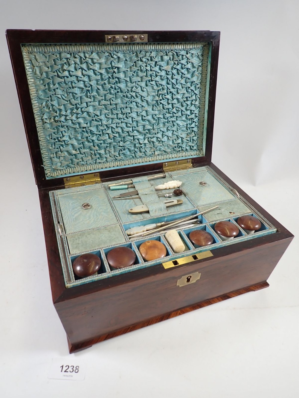 A Victorian rosewood needlework box with fitted interior including wooden reels and lift out tray,