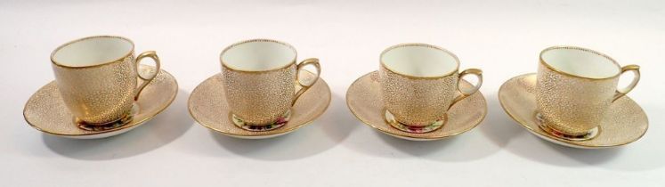 A Victorian set of four cups and saucers painted flowers to interior and with all over gilt exterior