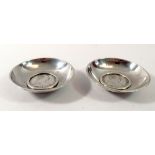 Two Marie Theresa coin inset white metal dishes, 9cm diameter