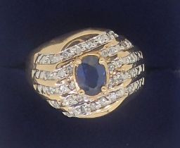 A 10k gold ring set oval cut sapphire in five diagonal rows of channel set diamonds, 5.6g, size W