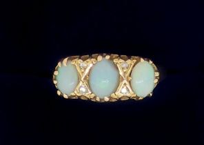 An 18 carat gold ring set three opals and four chip diamonds, size N, 3.1g