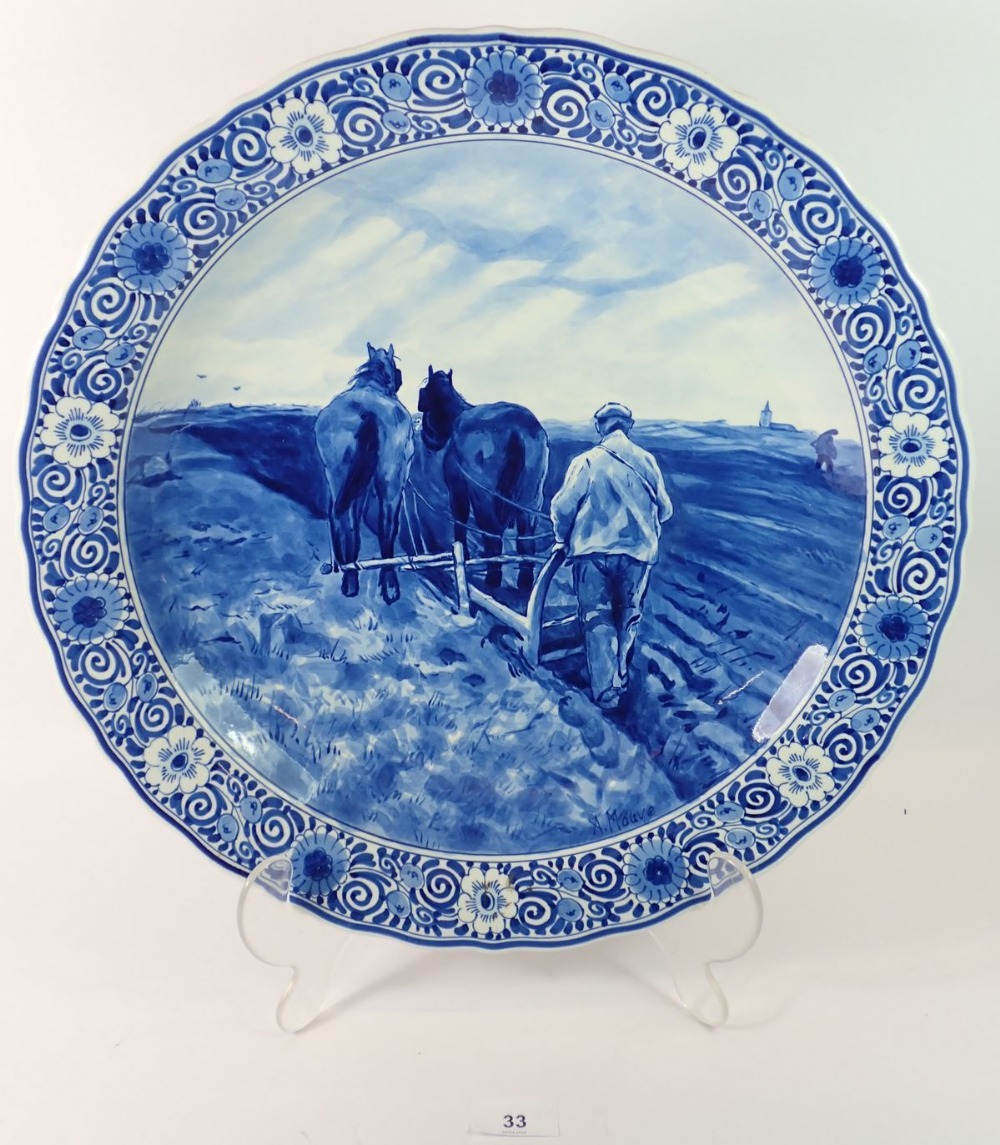 A Delft large circular dish painted ploughing scene, signed Mauve, 41cm diameter