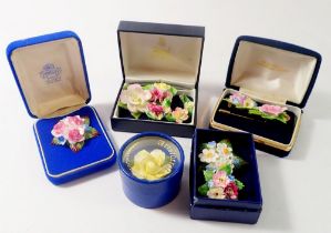 A collection of porcelain flower brooches