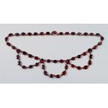 A Victorian triple swag gold necklace set oval cut garnets, 24.4g, unmarked