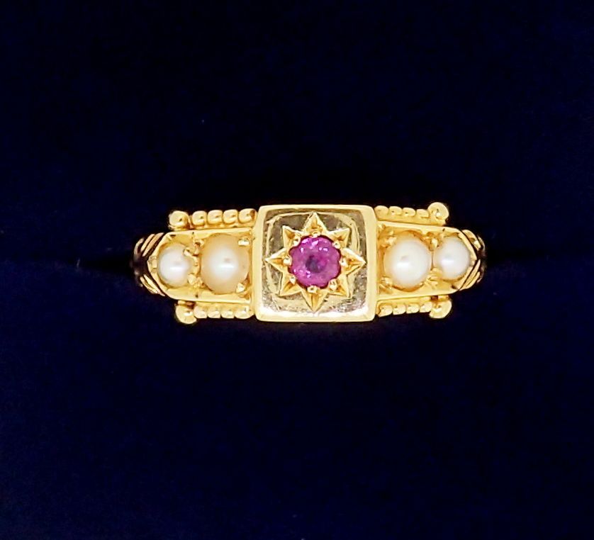 An Edwardian 18 carat gold ring set ruby flanked by four seed pearls, 2.5g, size M - boxed