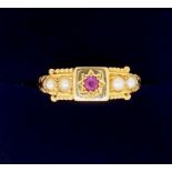 An Edwardian 18 carat gold ring set ruby flanked by four seed pearls, 2.5g, size M - boxed