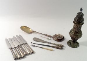 A group of silver handled tea knives, shoe horn and button hook plus white metal sugar caster and