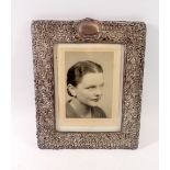 A rectangular silver mounted photograph frame with embossed berry and scrollwork decoration, 31 x