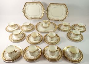 A Cauldon tea service with gilt greek key borders, pattern N64 comprising twelve cups and saucers,