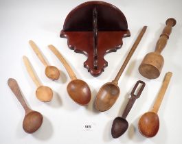 A group of nine various treen carved wooden spoons, a potato masher and a wooden bracket