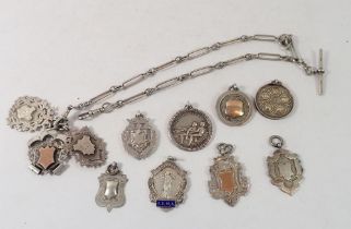 A silver fancy link fob chain and eleven silver fobs and medals