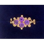 An antique style 9 carat gold ring set four amethysts in scrollwork and beaded surround, 1.6g,