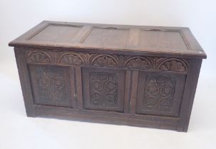 An 18th century oak coffer with carved three panel front, 124cm wide approx