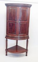 A large 19th century mahogany bow fronted corner cupboard on stand with secret drawer to detail