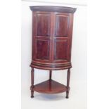 A large 19th century mahogany bow fronted corner cupboard on stand with secret drawer to detail