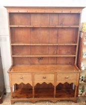 A 19th century oak and pine Welsh dresser with three tier back over three drawers, shaped apron