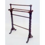 A Victorian rosewood finish towel rail on spiral turned supports