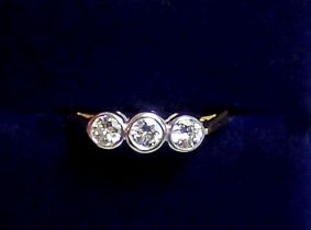 An 18ct white and yellow gold ring collet set three diamonds, size K, 2.2g