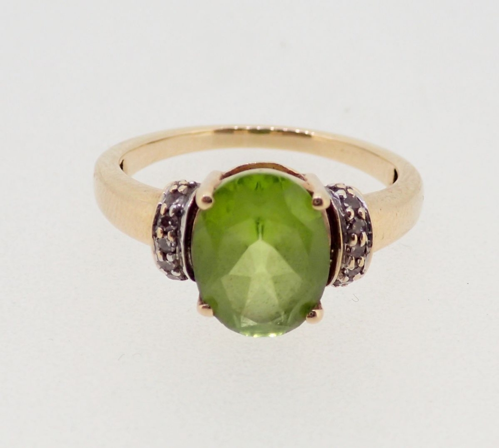 A 9 carat gold ring set peridot flanked by chip diamonds, size J, 2.5g - Image 2 of 4