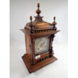 A Victorian mahogany mantel clock with turned decoration by Camerer Cuss, 45cm tall