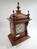 A Victorian mahogany mantel clock with turned decoration by Camerer Cuss, 45cm tall