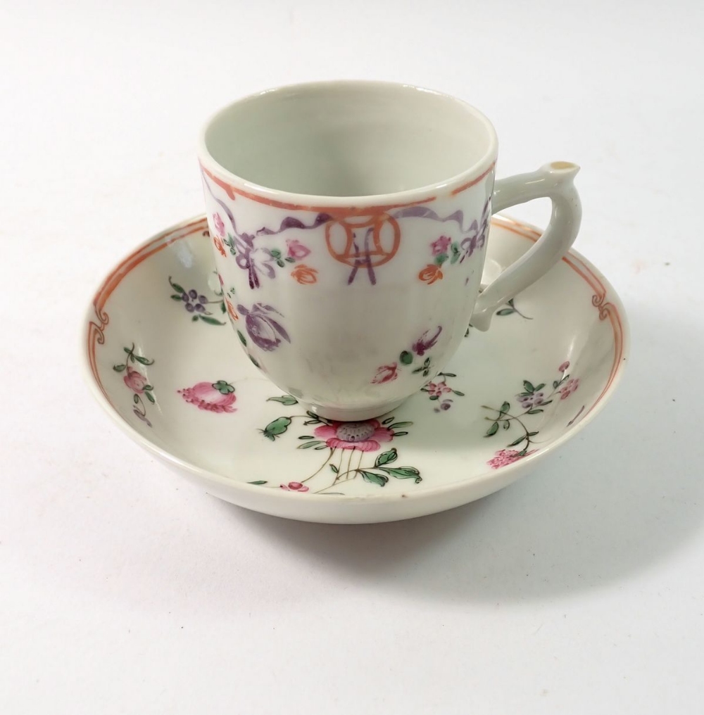 A Chinese famille rose cup and saucer painted ribbons and flowers