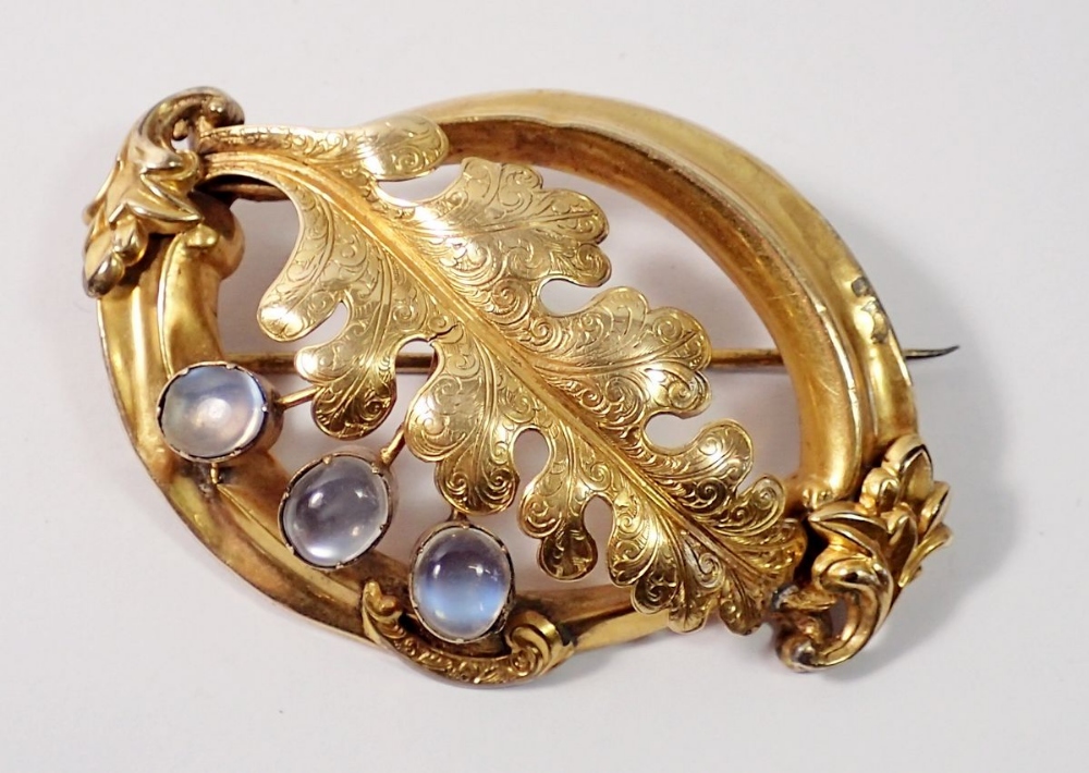 A Victorian pinchbeck large scrollwork brooch with large leaf and three moonstones, 14.5g