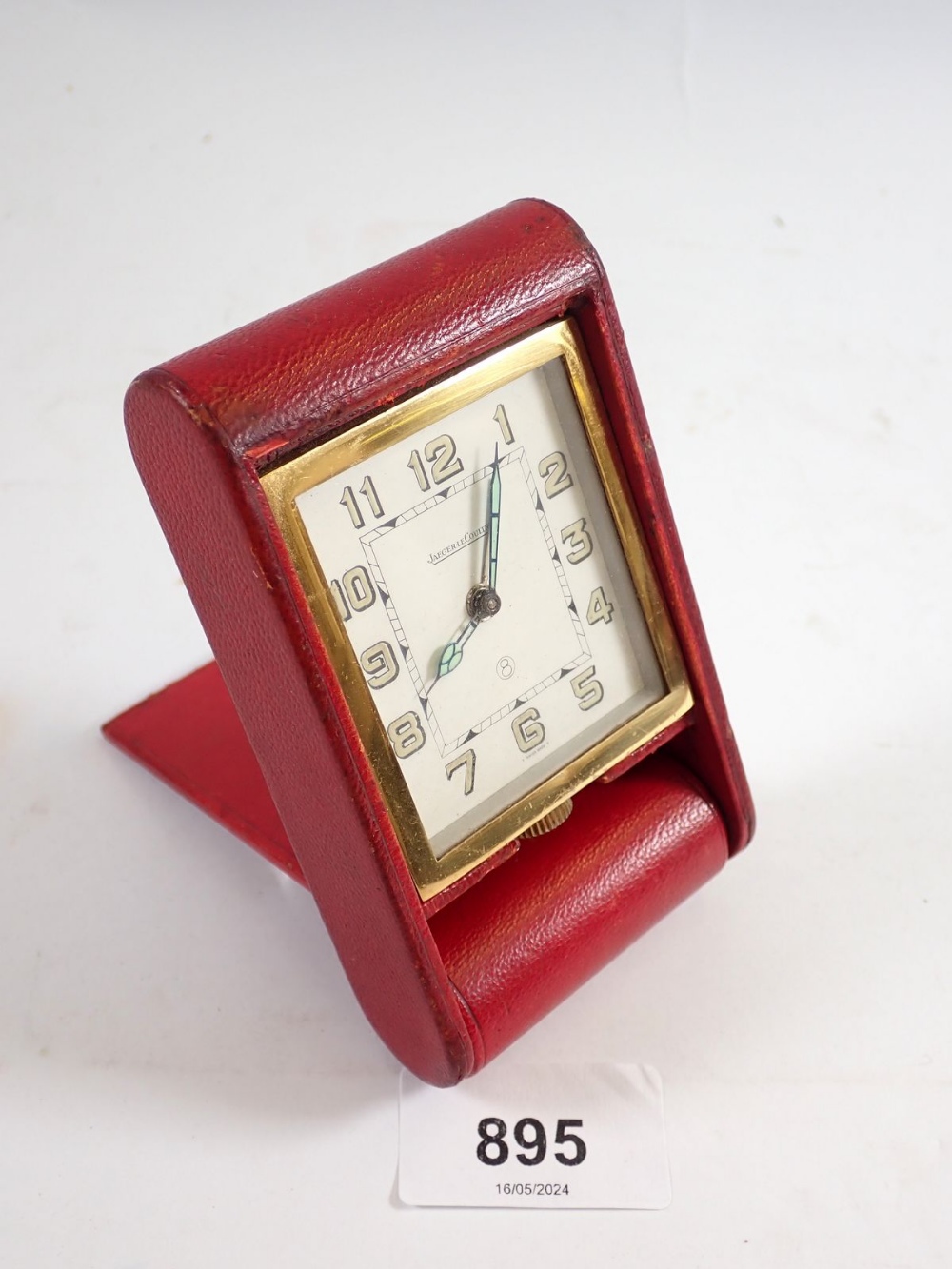 An Art Deco Jaeger le Coultre travel clock in red leather case