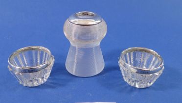 A silver and glass ribbed match striker and a pair of salts with silver rims