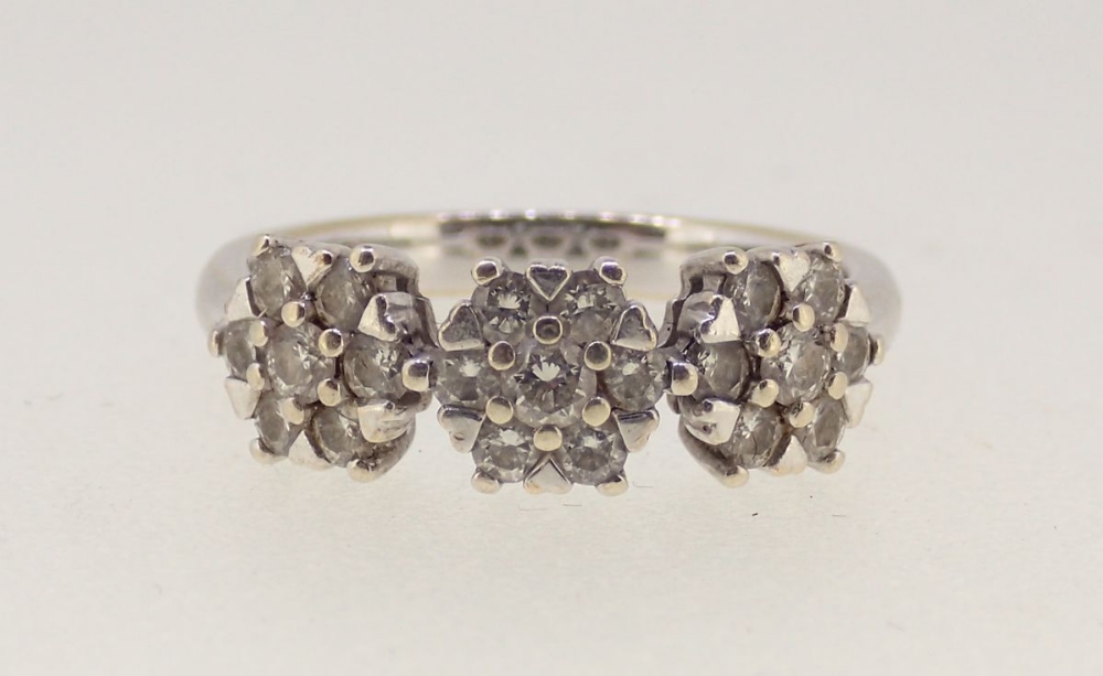 An 18 carat white gold ring illusion set triple diamond clusters, size I-J, 3.2g