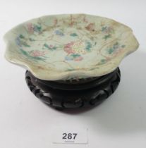 A Chinese Celadon glazed Canton saucer on carved wooden stand, 17cm wide