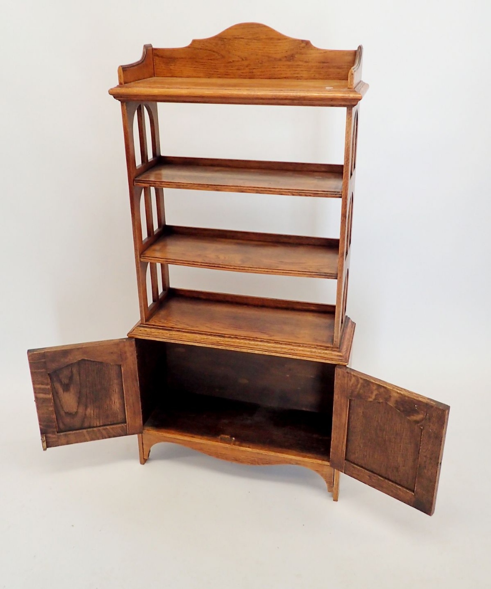 An early 20th century open oak bookcase with three shelves over cupboard, 60x128cm - Image 2 of 2