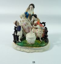 A 19th century porcelain group of lady with daughter and younger son, the mother feeding the