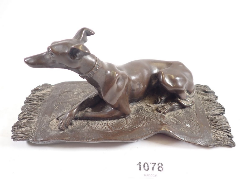 A bronze finish group recumbent whippet on rug, 19cm wide 'OFA' monogram