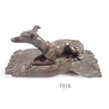 A bronze finish group recumbent whippet on rug, 19cm wide 'OFA' monogram