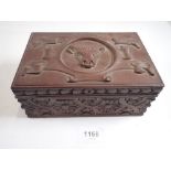 An antique carved wood box with bulls head to top and floral strap work, 18 x 12cm