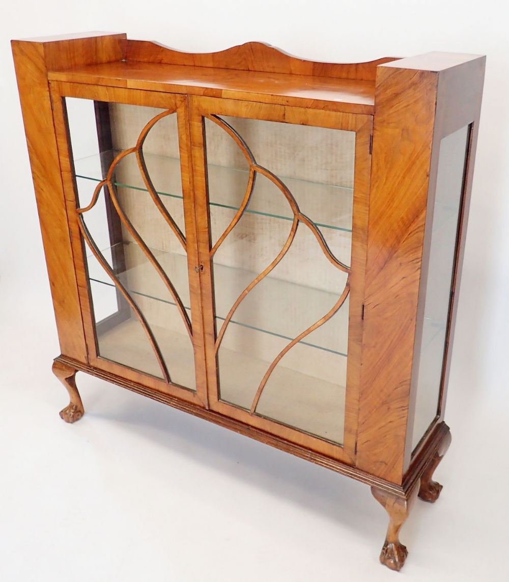 A 1950's walnut two door display cabinet with shell display bars, 119cm wide x 31cm deep