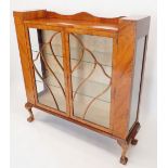 A 1950's walnut two door display cabinet with shell display bars, 119cm wide x 31cm deep