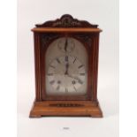 A late 19th century oak mantel clock with German movement marked Lenzkirch, the silvered face with