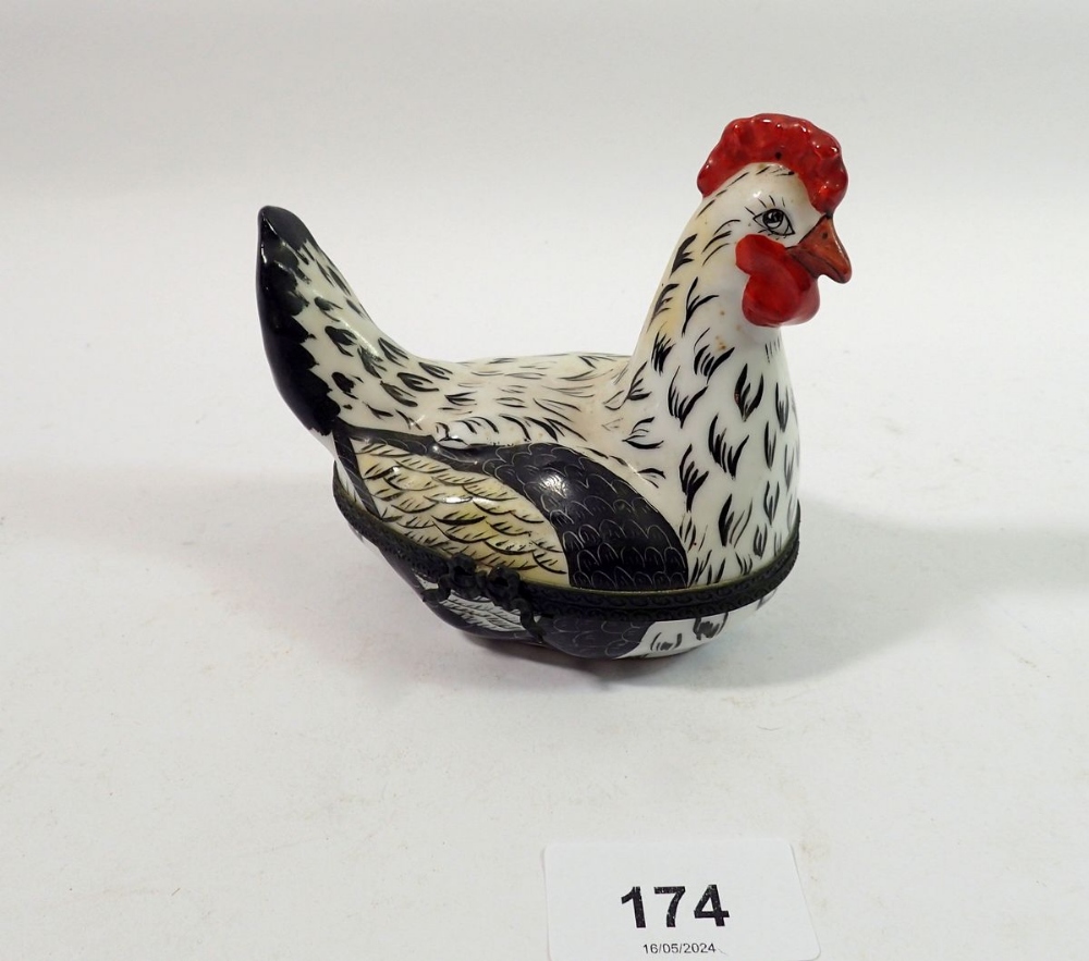 A Limoges trinket box in the form of a chicken with painted decoration, initialed E V, 10cm tall